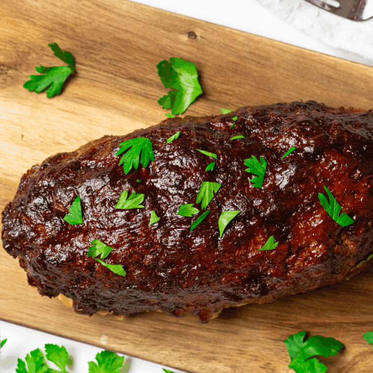 Slice of homemade meatloaf without eggs served with vegetables and mashed potatoes.