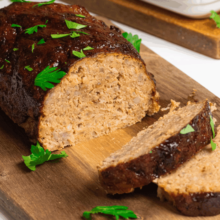 Slicing and serving meatloaf with comforting side dishes.