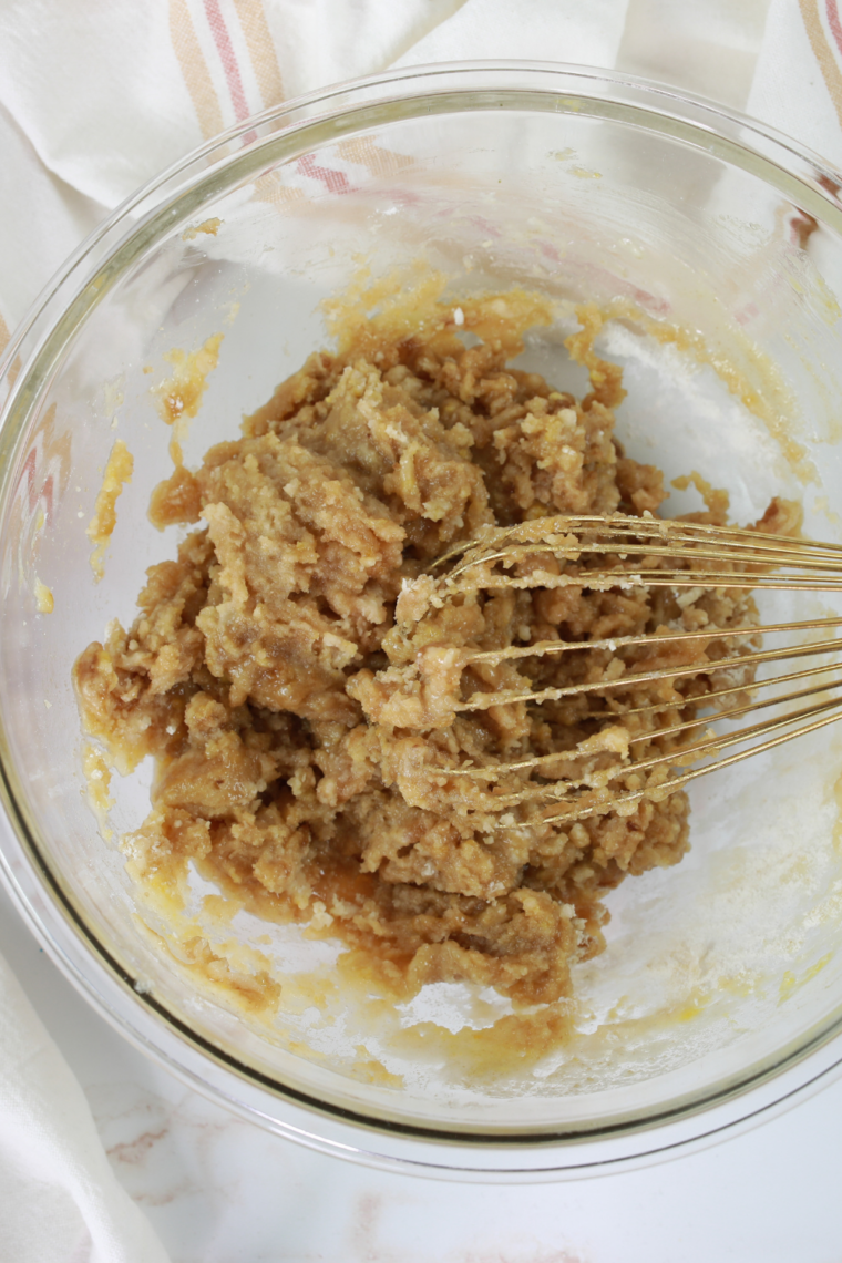mixing peanut butter sugar and egg into smooth cookie dough in bowl