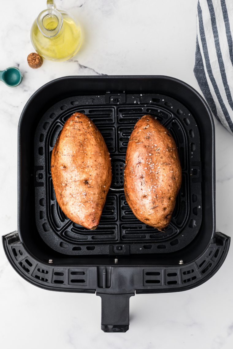 Sweet potatoes cooking in an air fryer basket at 400°F, perfectly spaced for even cooking