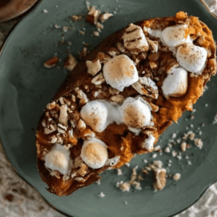 A delicious Texas Roadhouse loaded sweet potato topped with mini marshmallows, honey cinnamon butter, and caramel sauce.