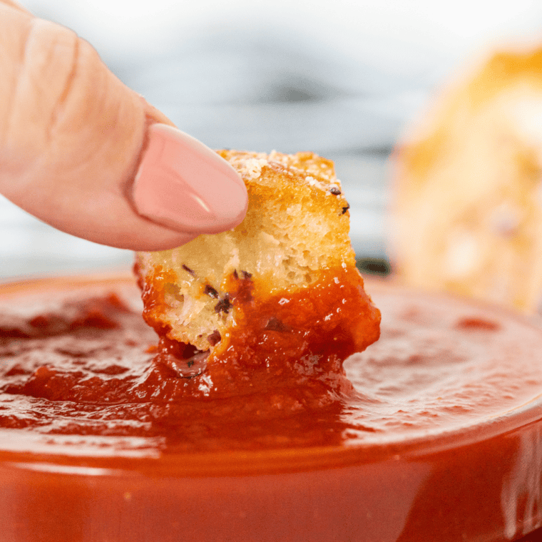 Air Fryer Mozzarella Pizza Bread with melted mozzarella cheese and pizza toppings, served hot on a wooden cutting board.