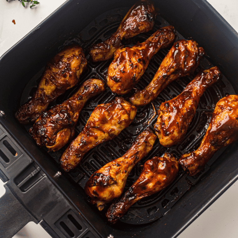 Golden-brown Air Fryer BBQ Chicken Legs coated in tangy barbecue sauce, served on a plate.