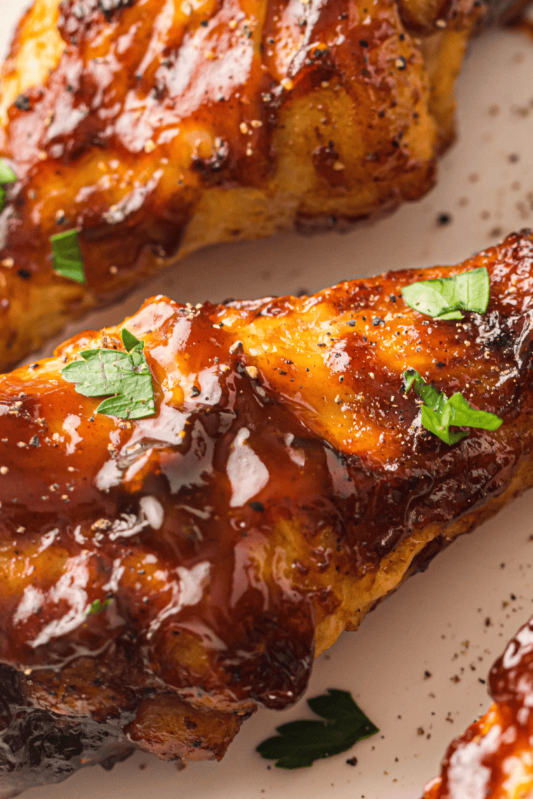 Crispy Air Fryer BBQ Chicken Legs coated in a rich, smoky sauce, served on a plate and ready to enjoy.