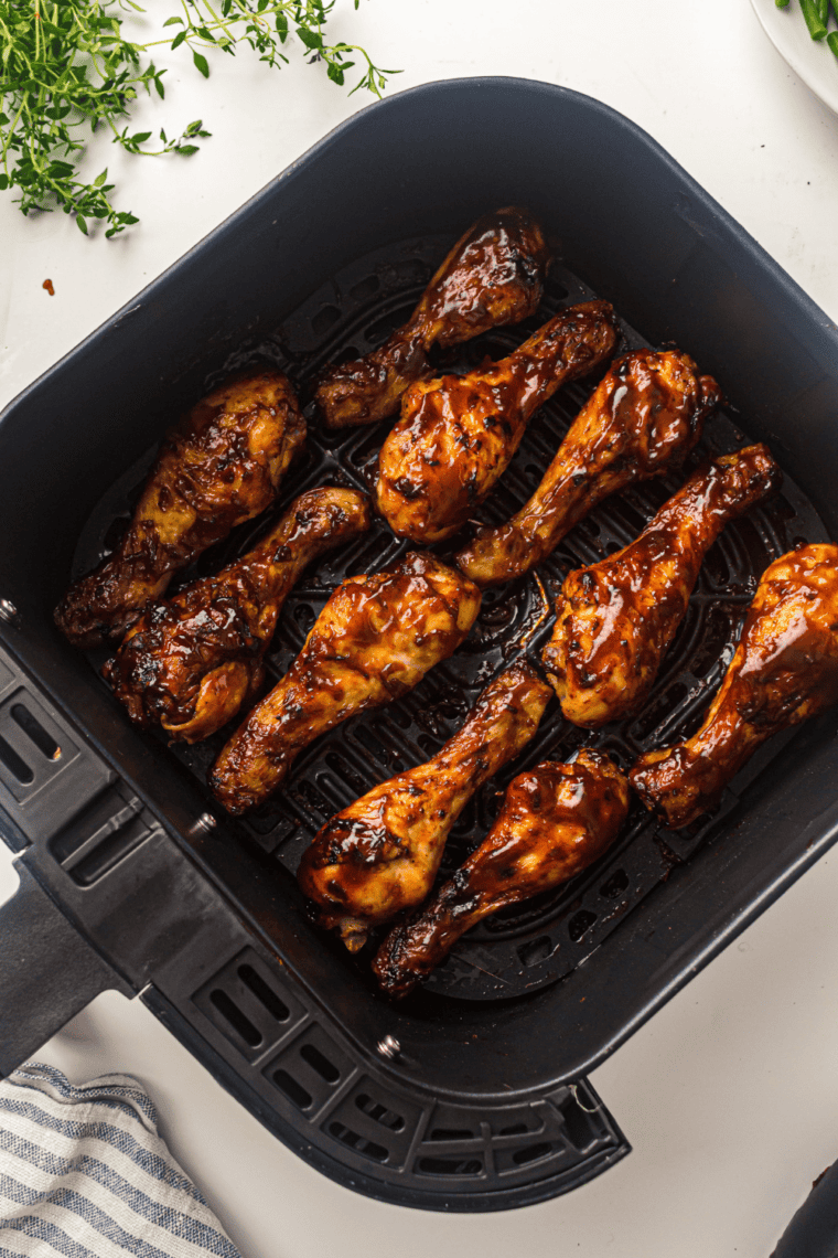 A plate of crispy, saucy Air Fryer BBQ Chicken Legs, cooked to perfection and ready to serve.