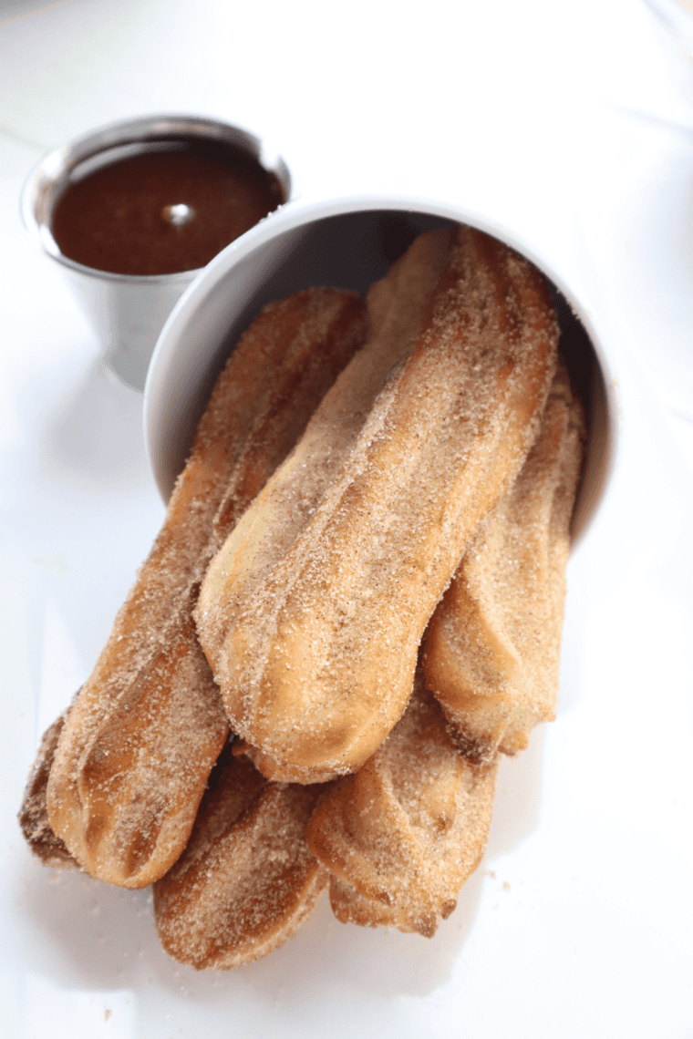 Crispy air fryer churros with ridged edges and cinnamon sugar coating arranged on a white plate