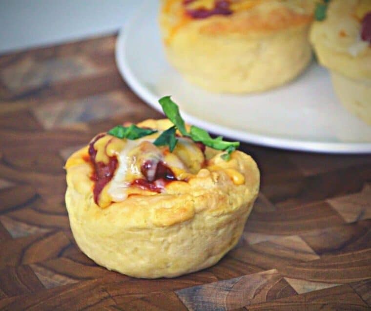 Air fryer Sloppy Joe cups in a muffin tin, filled with ground beef mixture and melted cheddar cheese, ready to serve.