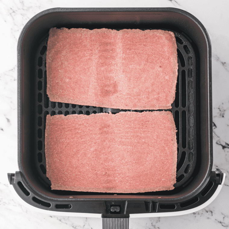 Frozen Steak in the air fryer basket.