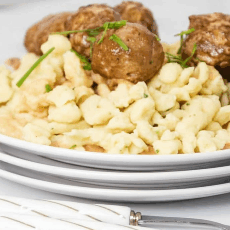 Air fryer Swedish meatballs coated in creamy sauce, garnished with fresh parsley, served on a plate.
