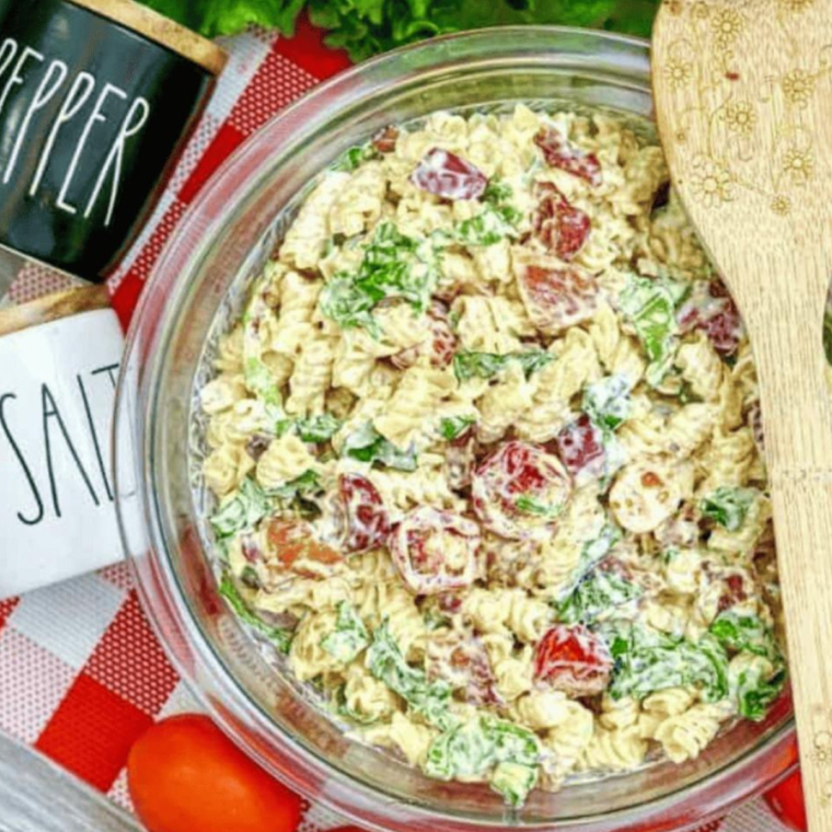 A close-up shot of a spoon serving creamy Instant Pot BLT Pasta Salad, showing the crispy bacon and fresh veggies.