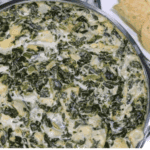 A bowl of creamy Instant Pot Copycat Applebee’s Spinach and Artichoke Dip, ready to serve with chips or bread for dipping.