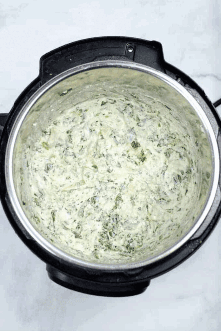 A creamy bowl of Instant Pot Copycat Applebee’s Spinach and Artichoke Dip, ready to serve with bread, chips, or crackers for dipping.