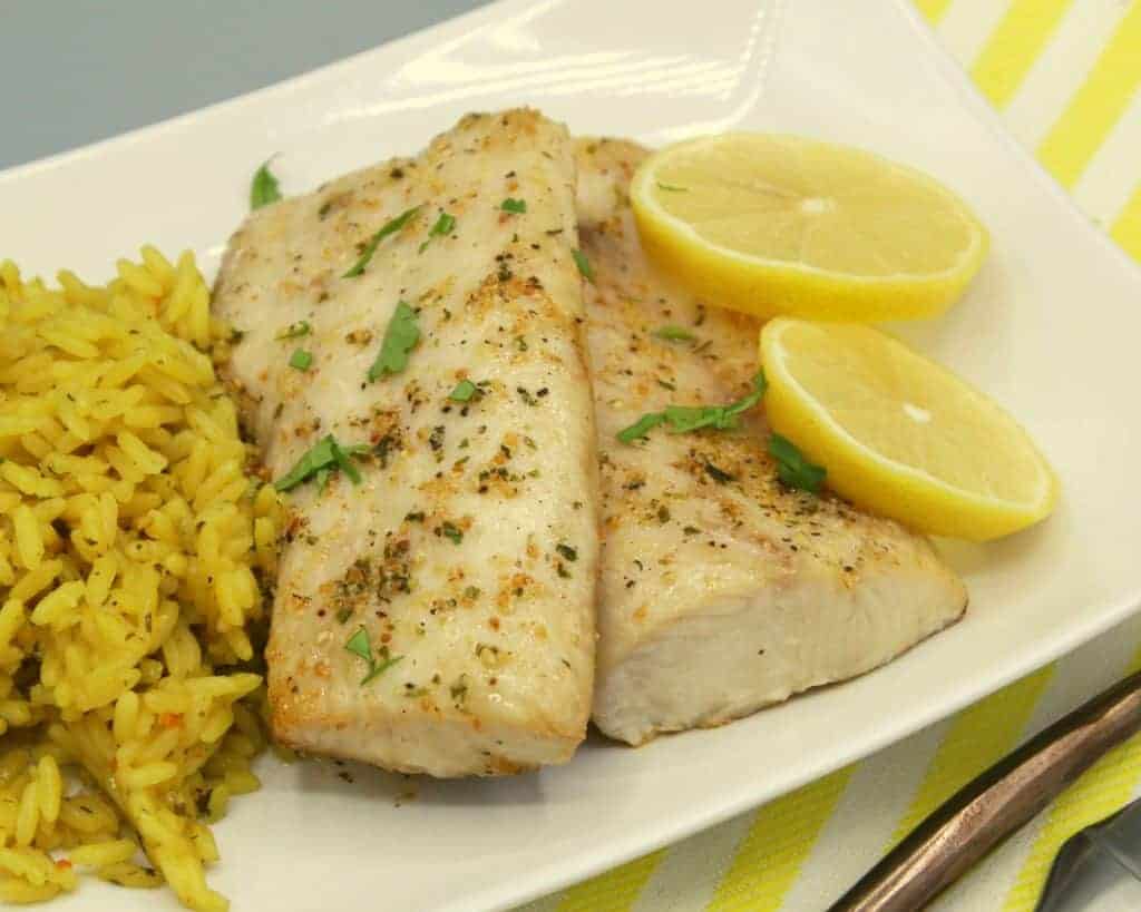 mahi mahi recipe made in air fryer on plate with rice and lemon wedges