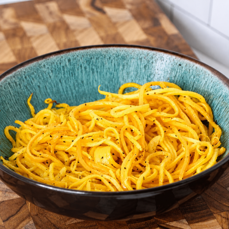 Spiralized butternut squash noodles with Alfredo sauce and grated Parmesan