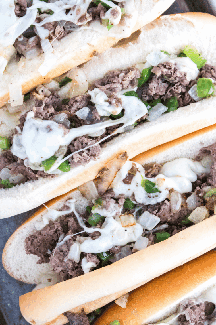 Homemade Arby’s Angus Cheesesteak sandwich with melted cheese and peppers on a hoagie roll.