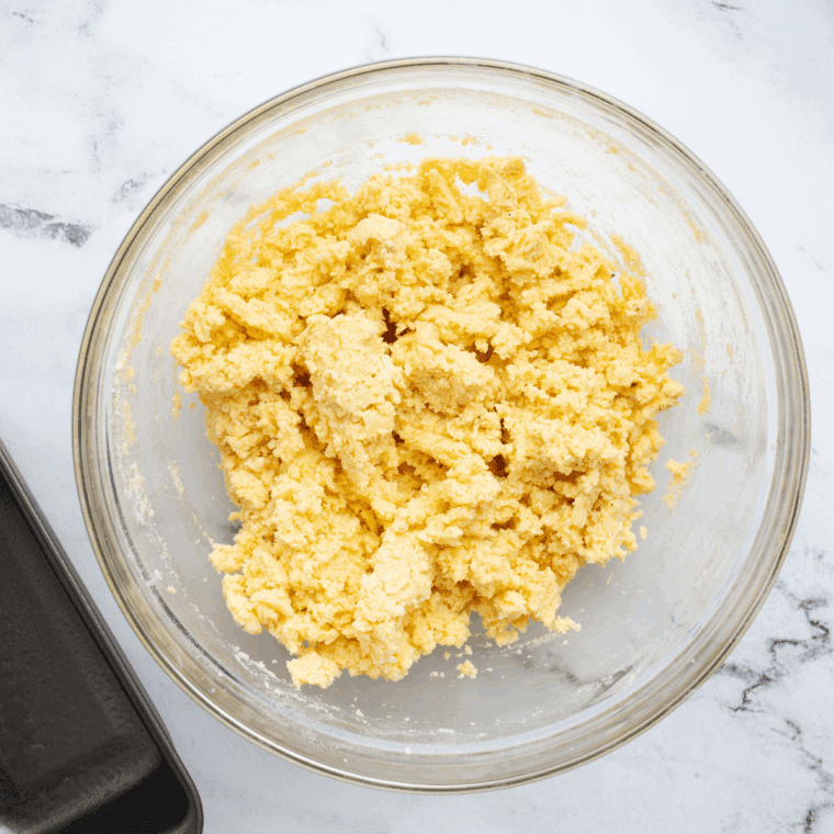 Combining flour, powdered sugar, cornstarch, salt, and butter to form a crumbly crust mixture for lemon bars.