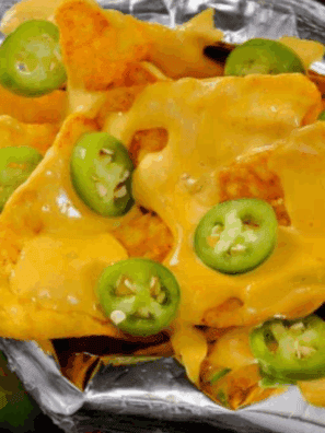 Bowl of smooth, creamy Taco Bell-style cheese sauce with chips ready for dipping.