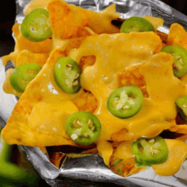 Bowl of smooth, creamy Taco Bell-style cheese sauce with chips ready for dipping.