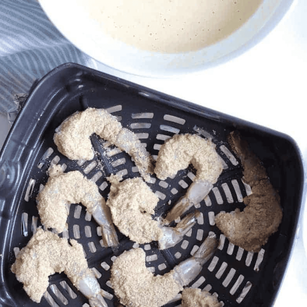 Breaded Beer Battered Shrimp in the air fryer basket.