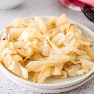 Air fryer caramelized onions, soft and deep golden brown, in a white bowl