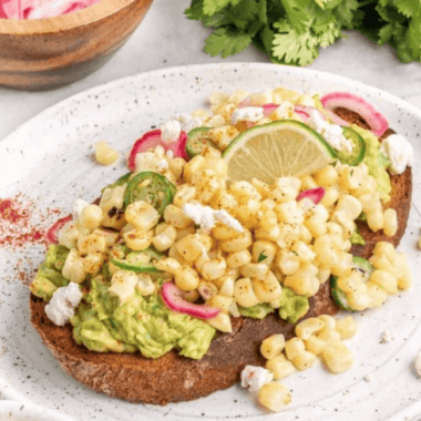 air fryer elote avocado toast topped with cheese, lime, and cilantro