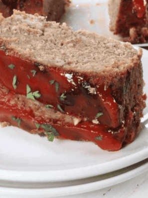 Slice of copycat Boston Market meatloaf on a white plate with hickory ketchup glaze