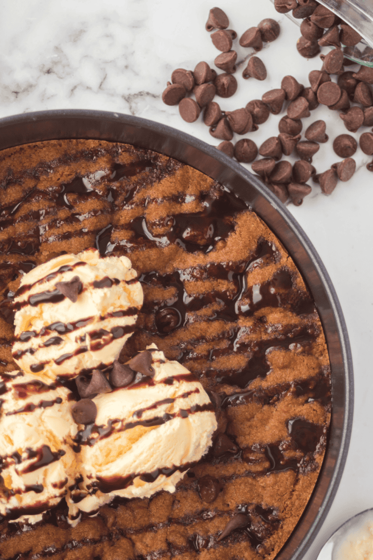 Air fryer chocolate chip pizookie with golden edges and gooey center served in a skillet.