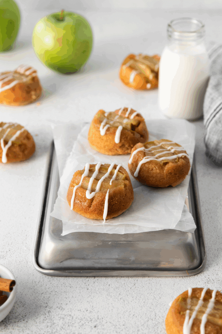 Slice of Easy Amish Apple Cake on a plate, showing moist cinnamon apple layers and a golden brown crust, topped with a dusting of powdered sugar.