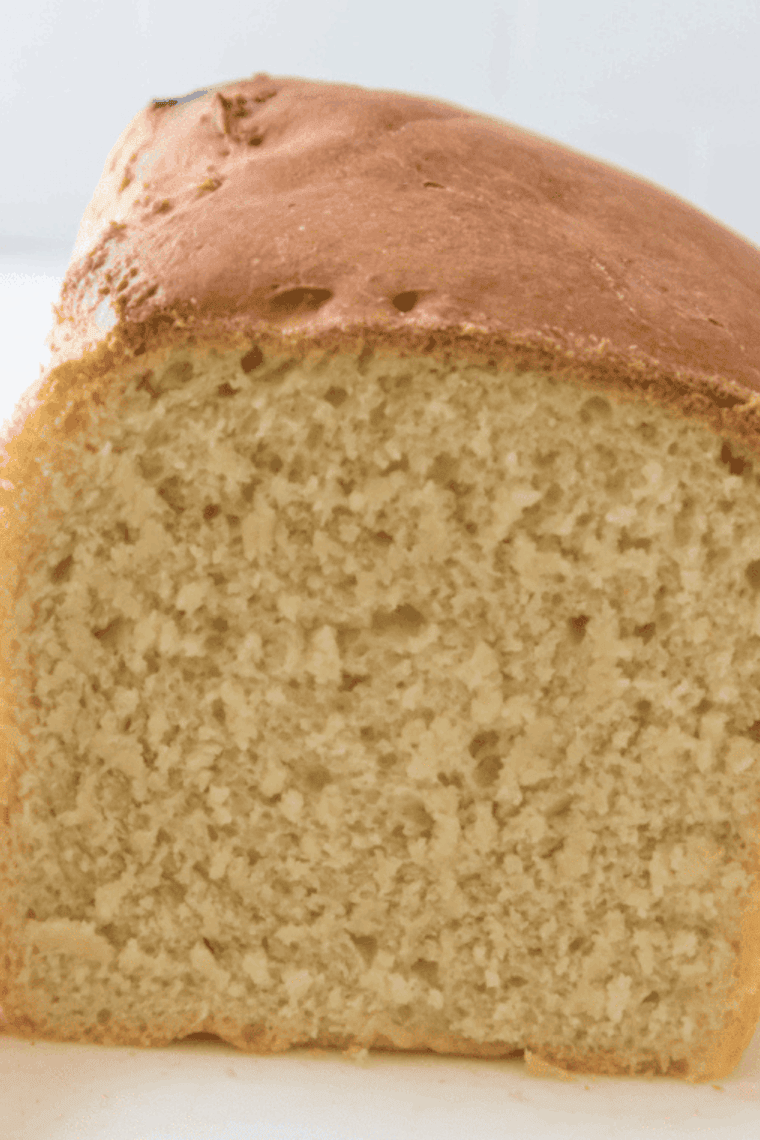 freshly baked golden brown farmhouse white sandwich bread on cutting board