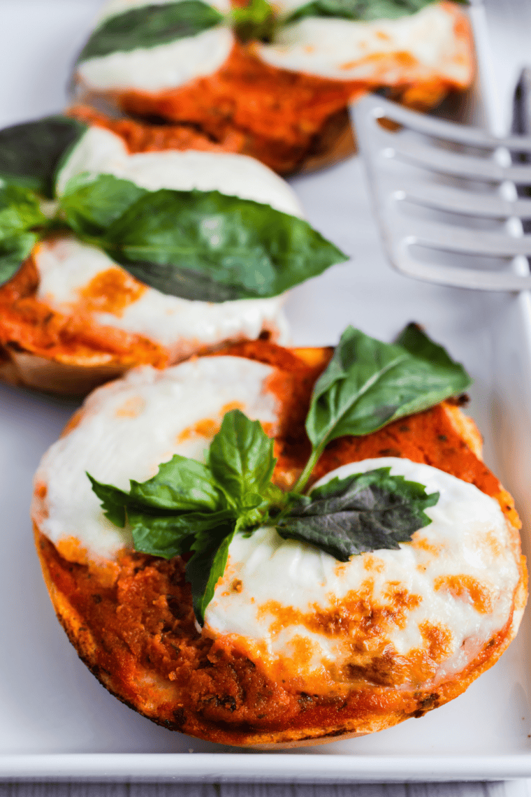 Air Fryer Margherita Pizza Bagels topped with fresh tomatoes, basil, and melted mozzarella on a golden bagel