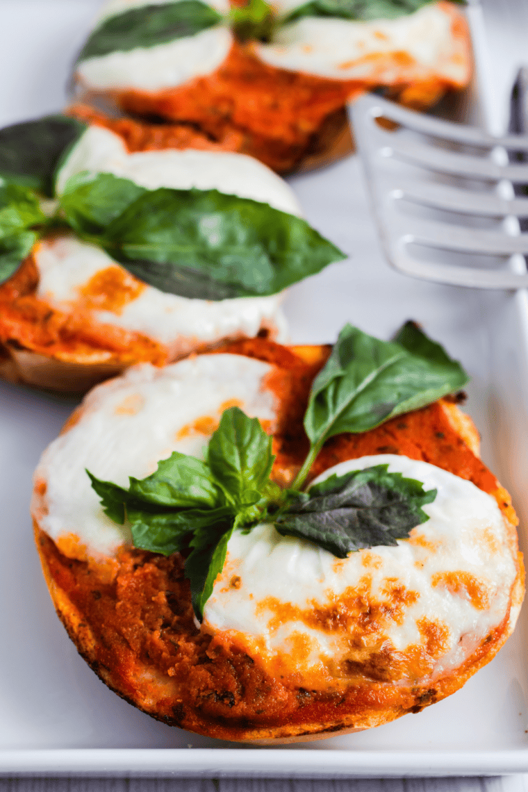 Air fryer margherita pizza bagels with melted mozzarella, marinara sauce, and fresh basil on a crispy bagel slice.