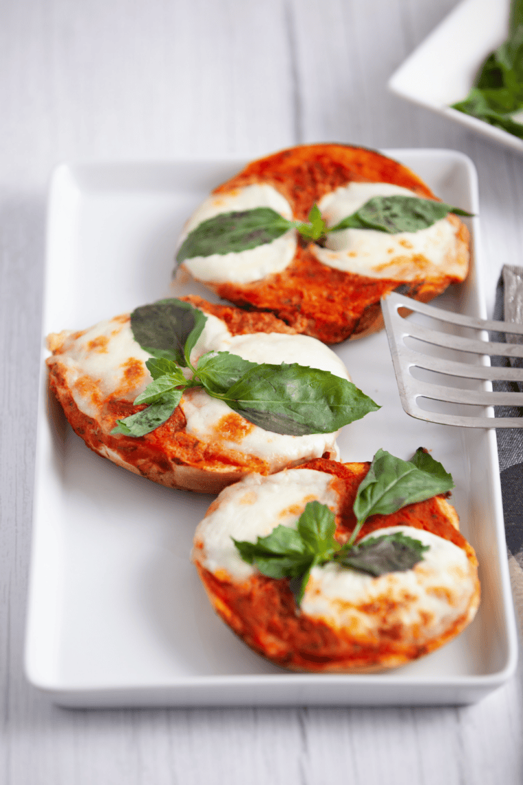 Air fryer margherita pizza bagels with melted mozzarella, fresh basil, and marinara sauce on crispy bagels.