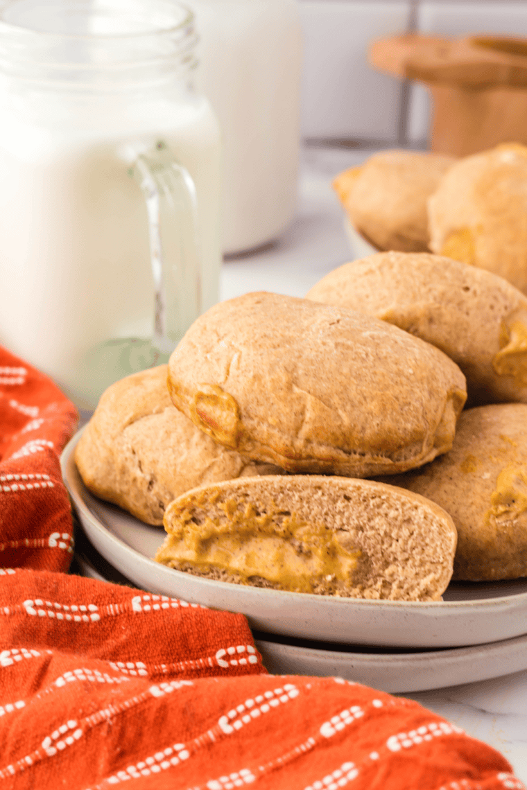 Golden air fryer pumpkin donuts filled with smooth, creamy pumpkin custard on a plate.