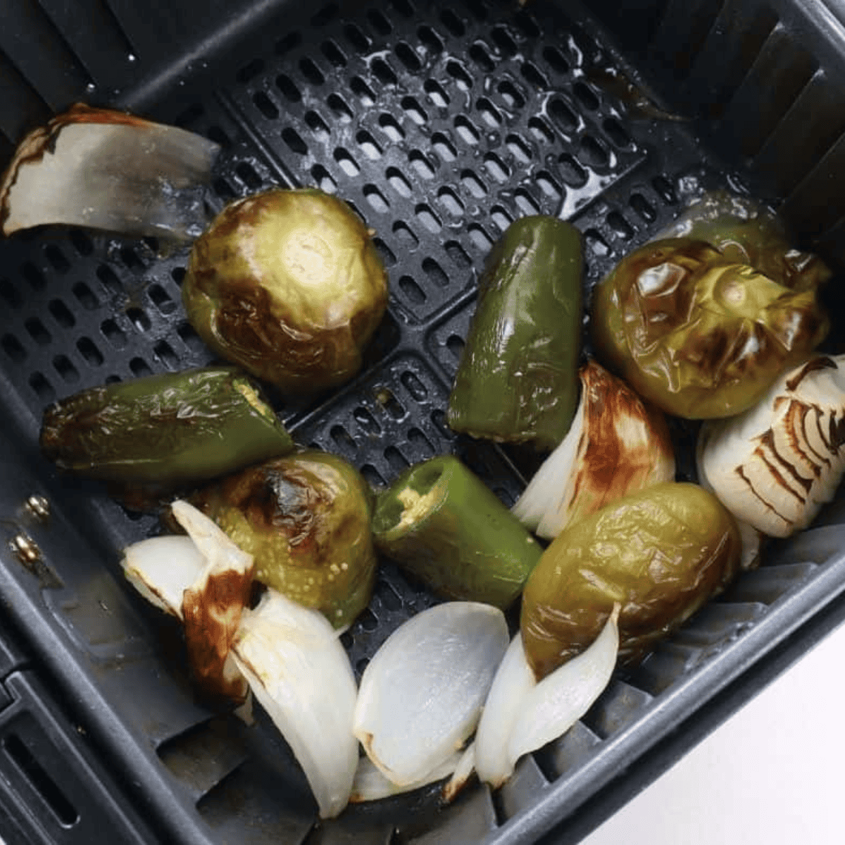 Cooked vegetables in the air fryer basket.