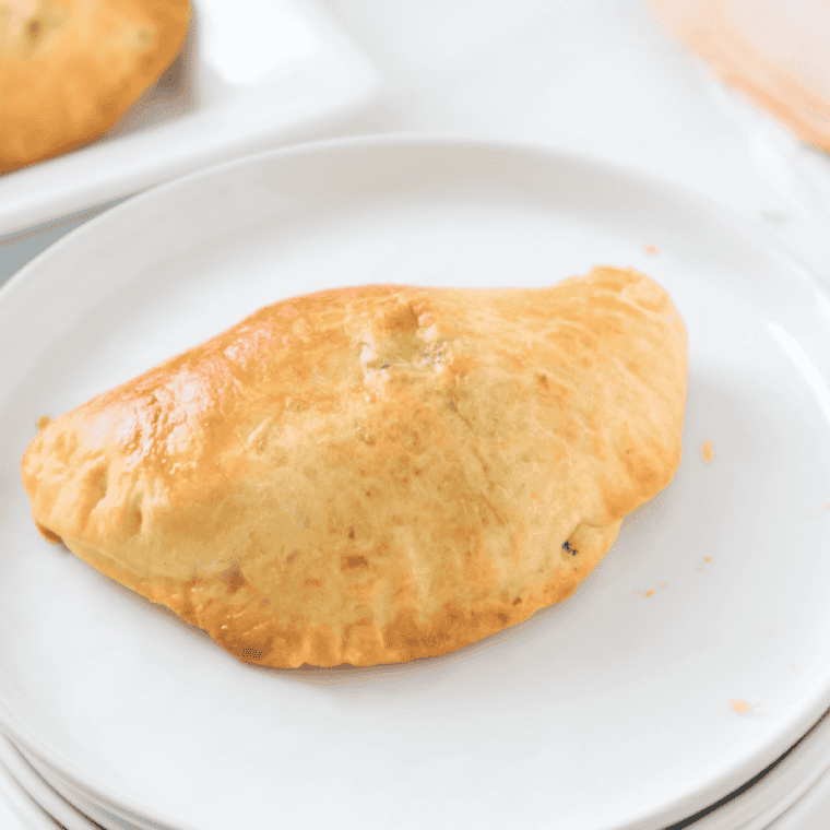 Golden brown air fryer turkey turnovers filled with turkey and cheese, served on a plate ready to eat