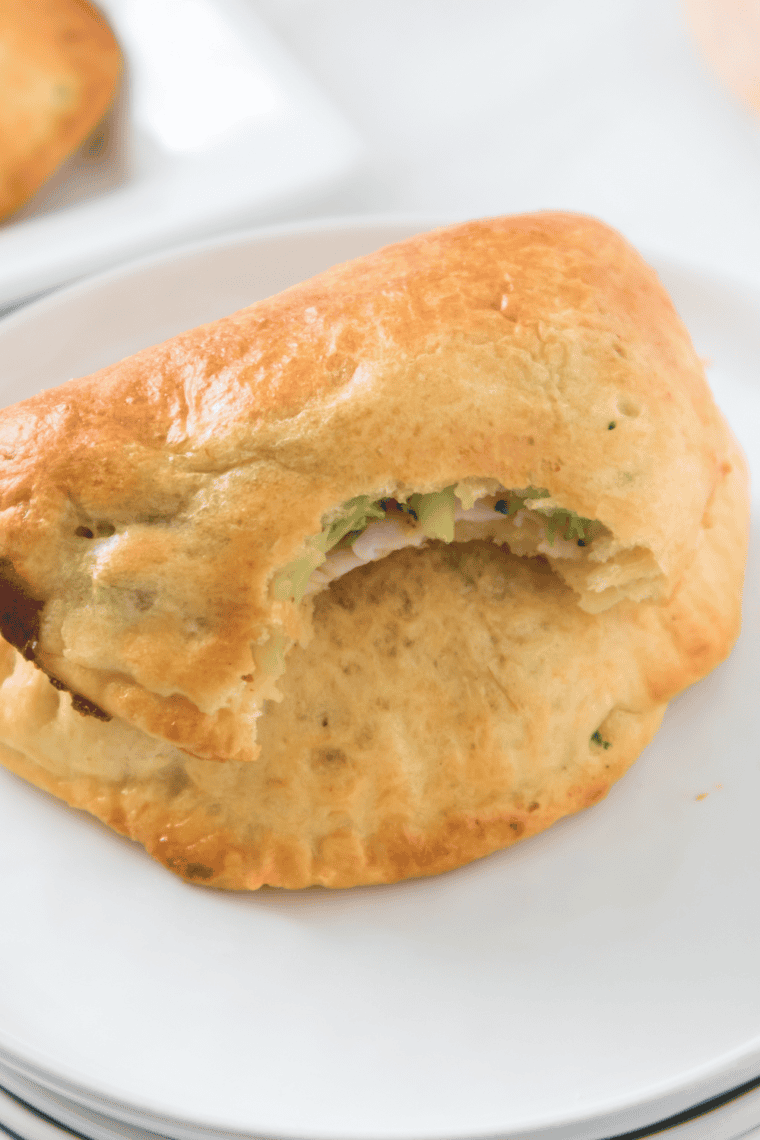 Crispy golden air fryer turkey turnovers filled with turkey and vegetables, served hot on a plate