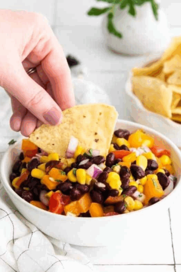 Bowl of Applebee’s black bean and corn salsa with fresh cilantro and tortilla chips