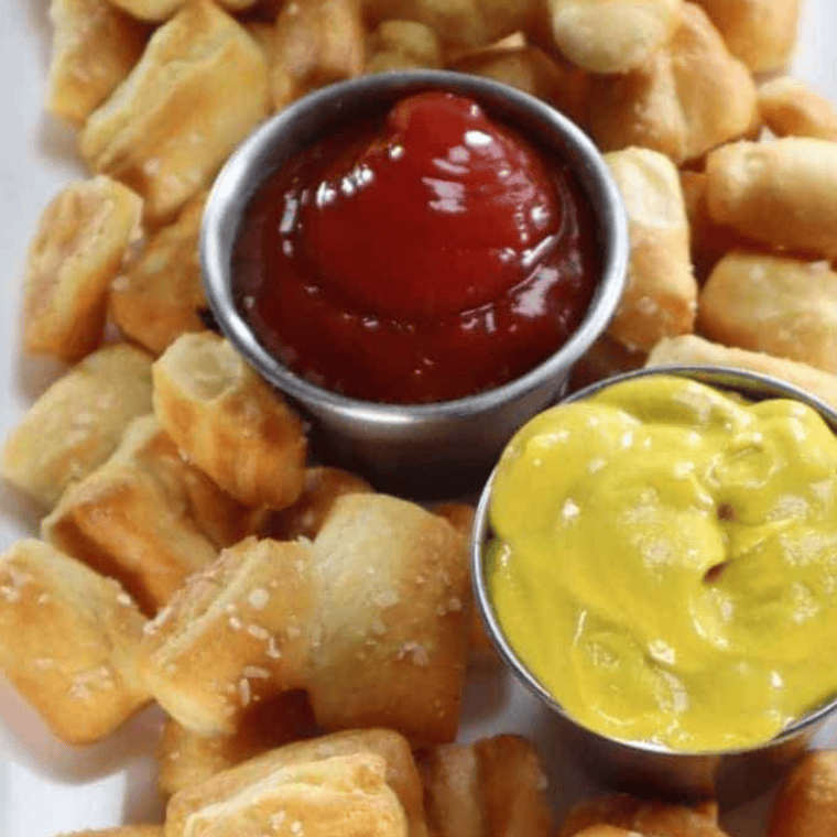 Bowl of homemade Arby’s Three Pepper Sauce served with soft pretzels for dipping.