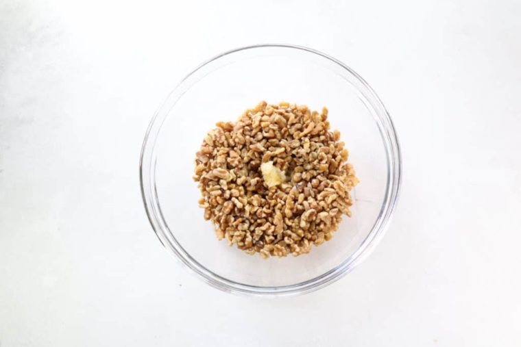 overhead process shot: walnuts and butter in a large glass bowl