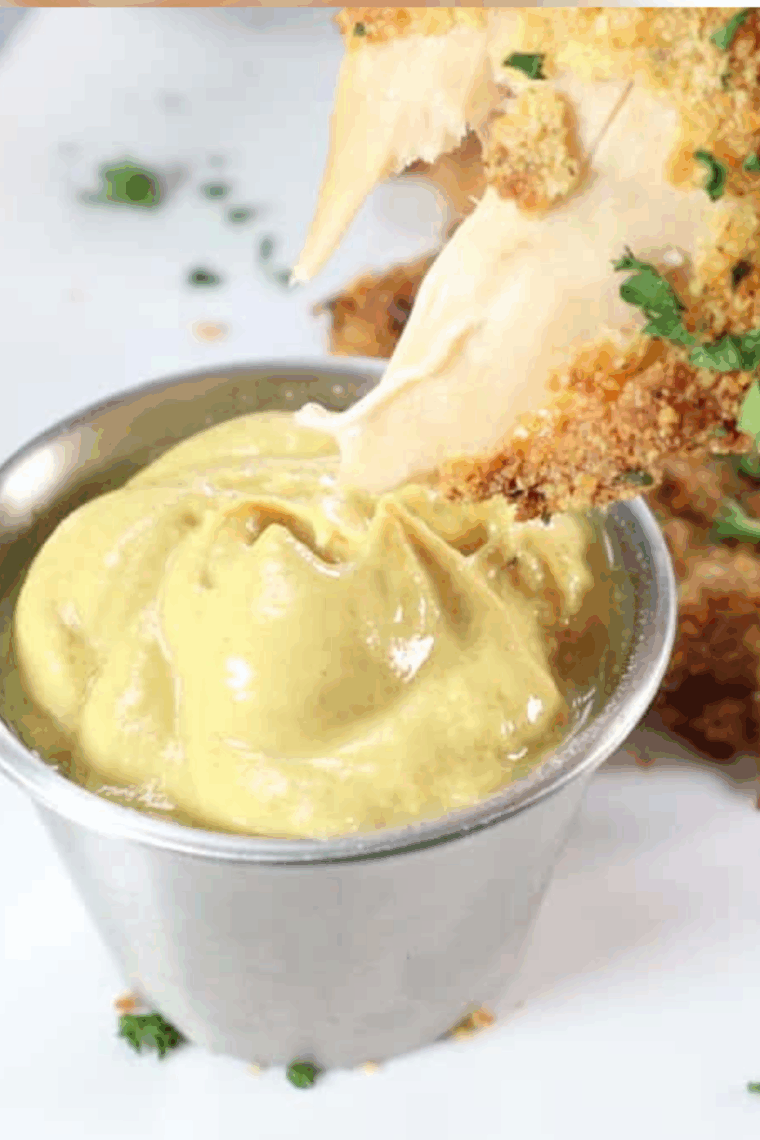 Homemade copycat McDonald’s hot mustard sauce served in a small bowl with chicken nuggets nearby.