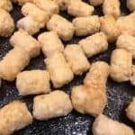 single layer of frozen tater tots in air fryer basket 