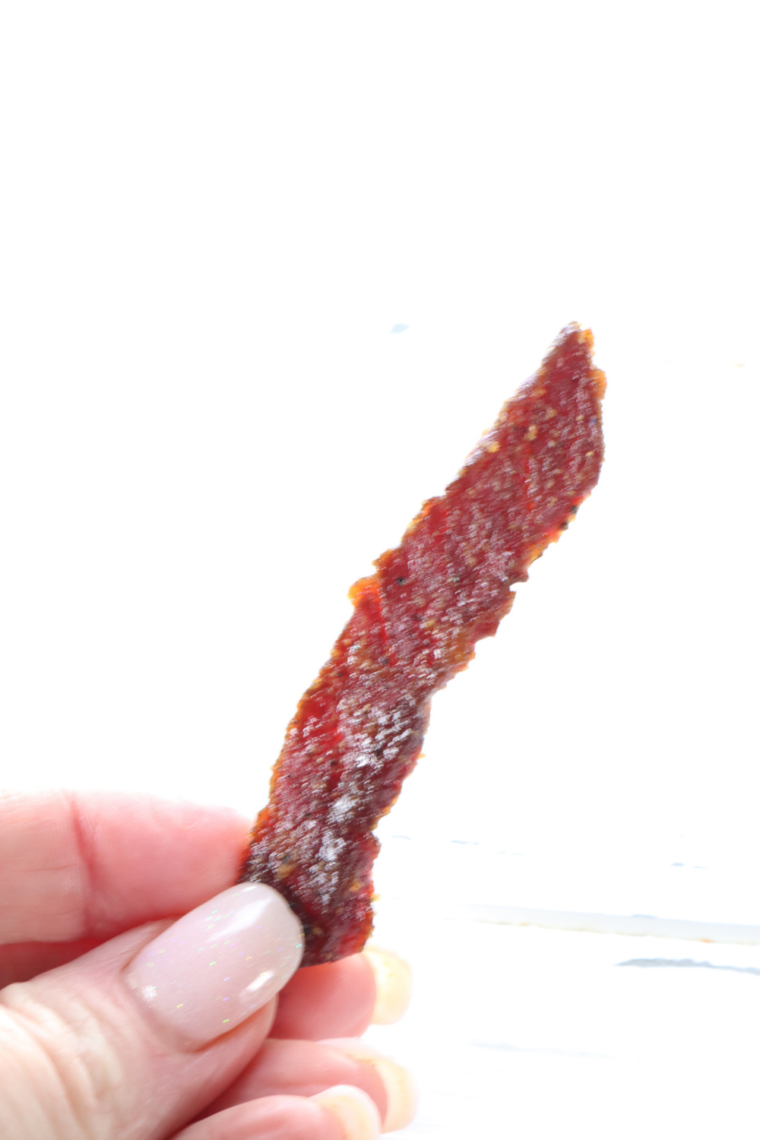 Air fryer beef jerky strips overflowing from a clear glass mason jar &mdash; perfect homemade high-protein snack