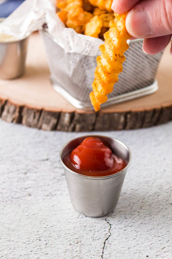 dipping air fryer crinkle fries in ketchup