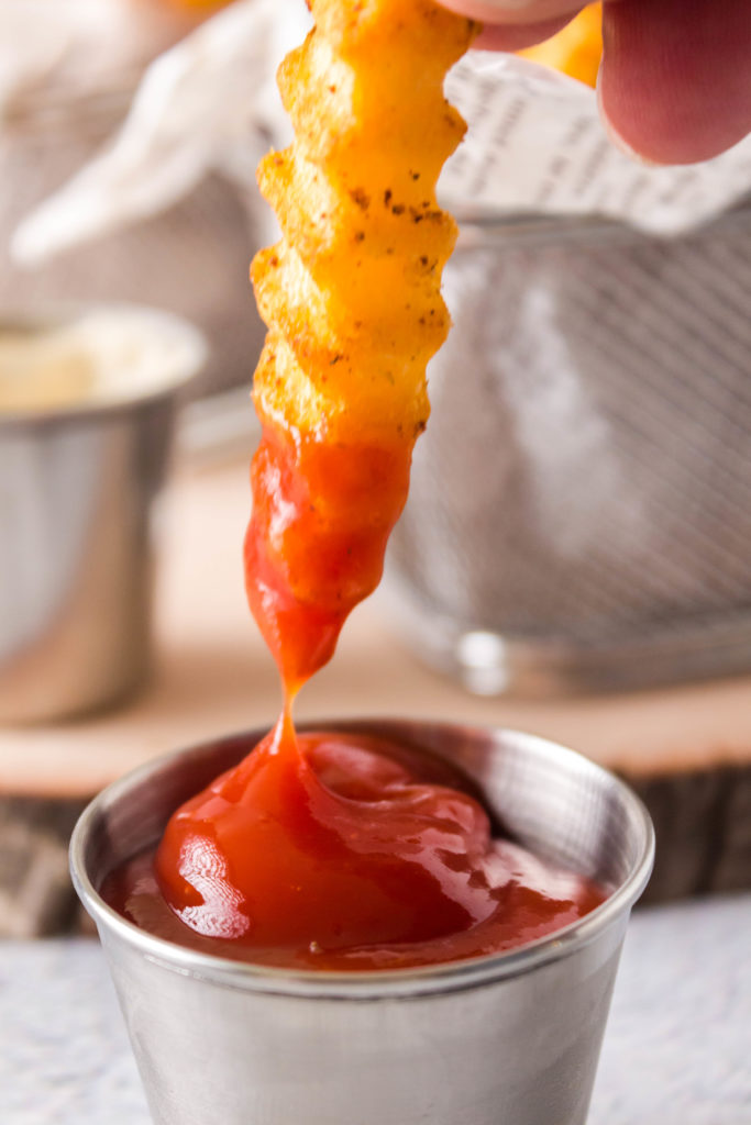 seasoned crinkle fry dipped in ketchup