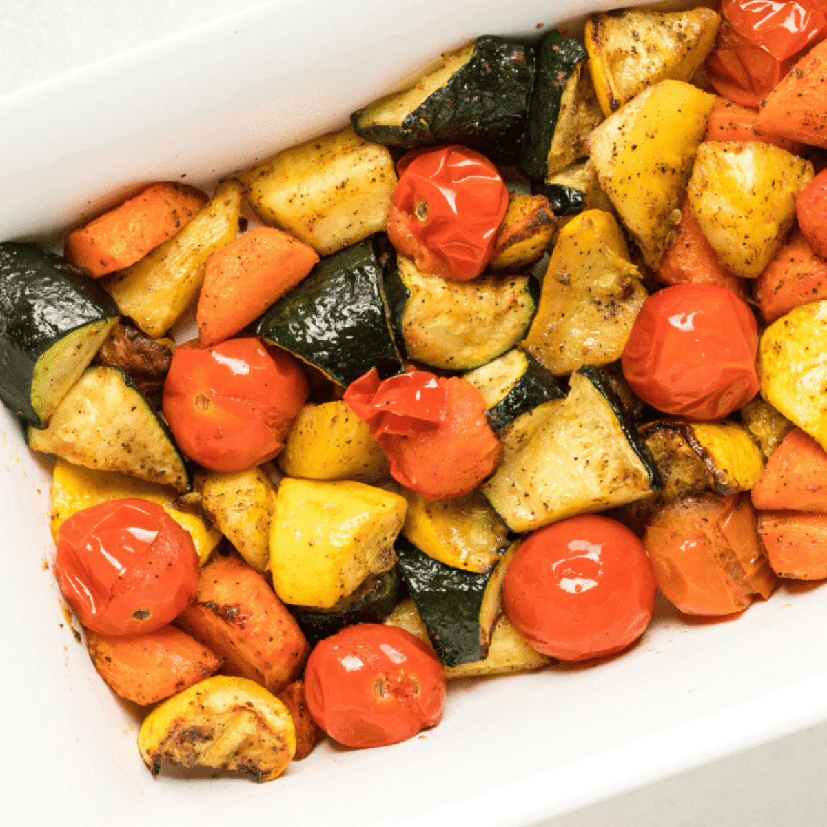 Colorful air fryer roasted vegetables including carrots, broccoli, and bell peppers served in a bowl.