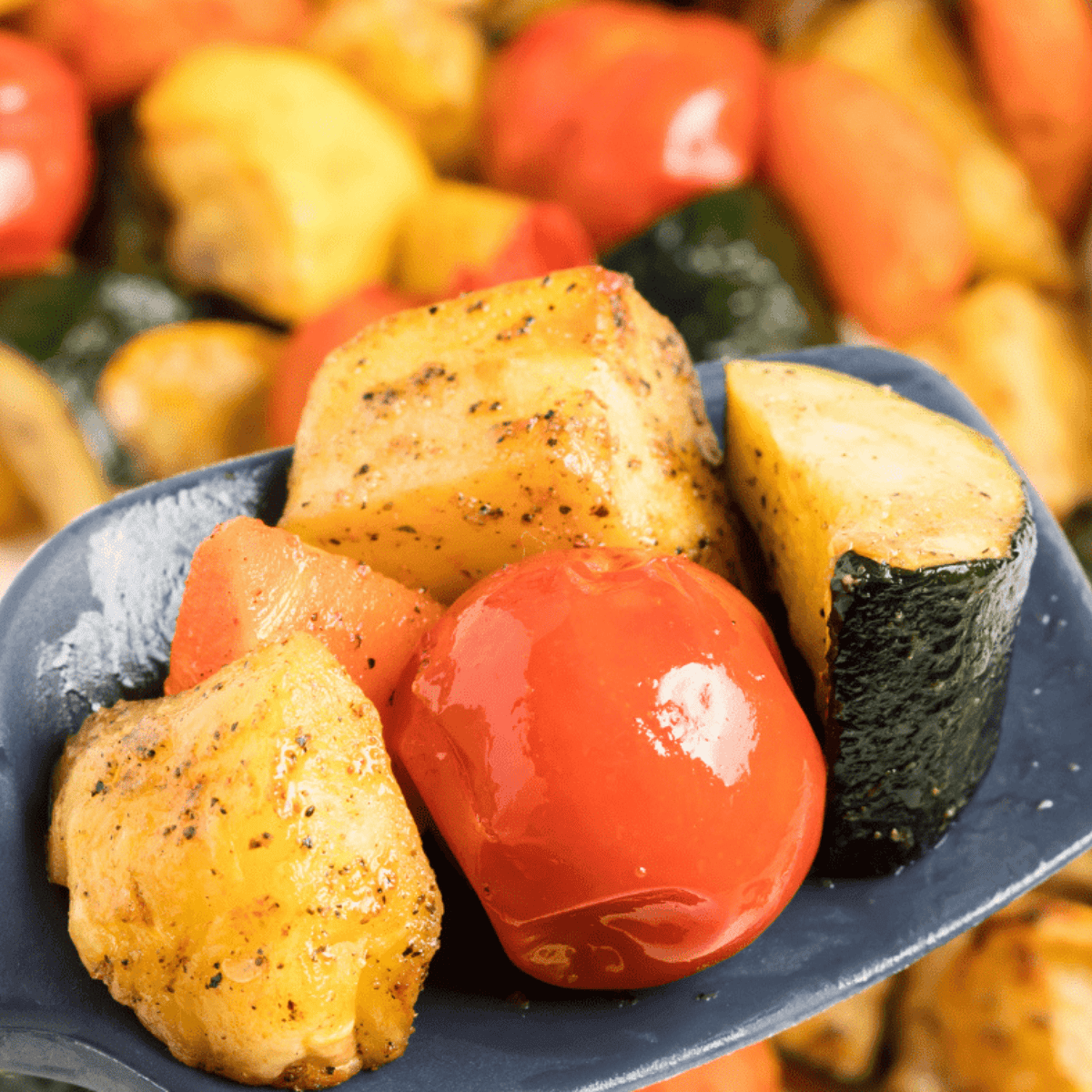 Crispy air fryer roasted vegetables including carrots, zucchini, and peppers served in a white bowl.