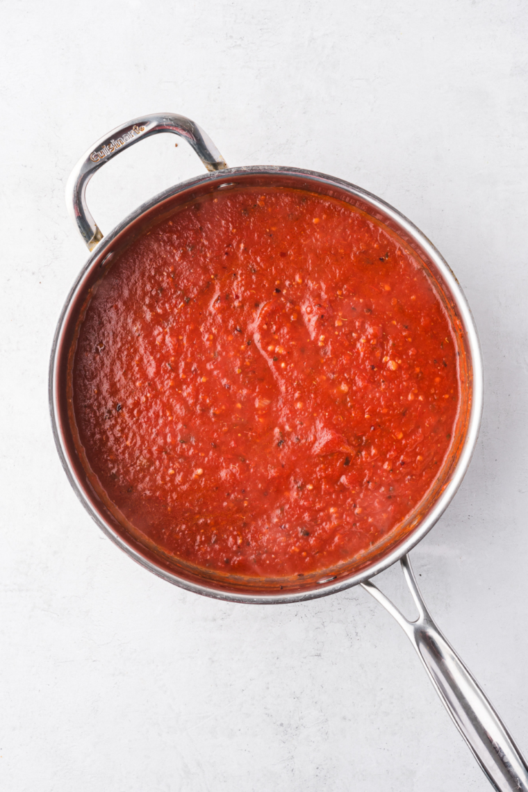 Crushed tomatoes and tomato paste added to saucepan.