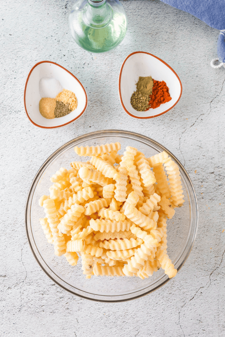 Soaked fries being drained and patted completely dry on a kitchen towel before cooking.