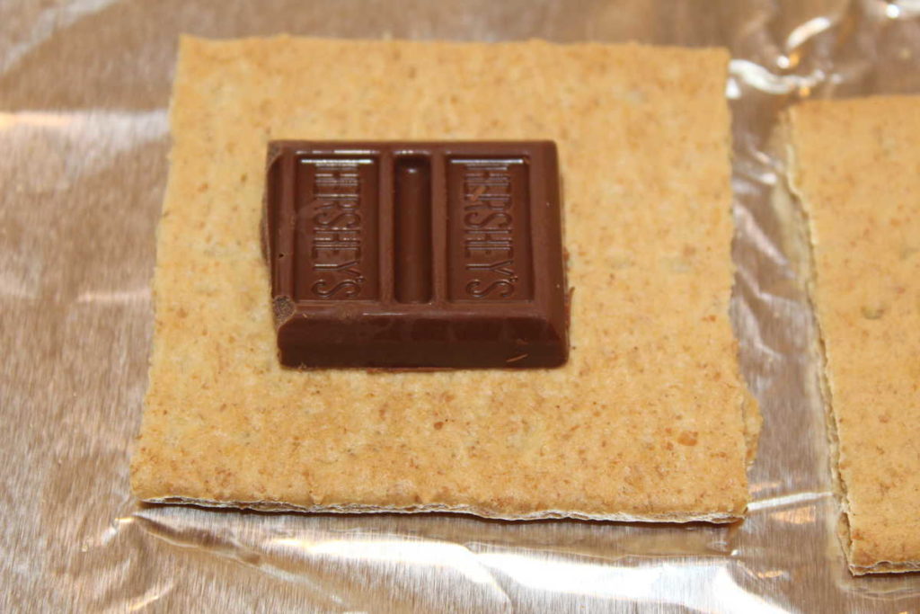 small piece of chocolate on half a graham cracker