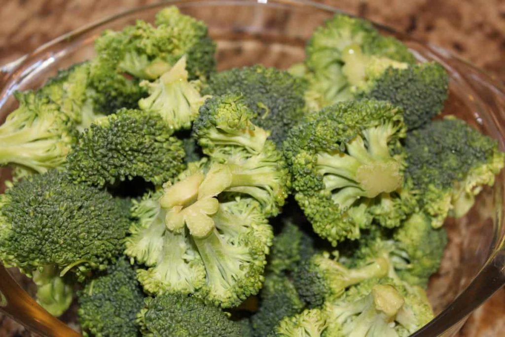 raw broccoli florets in a glass bowl